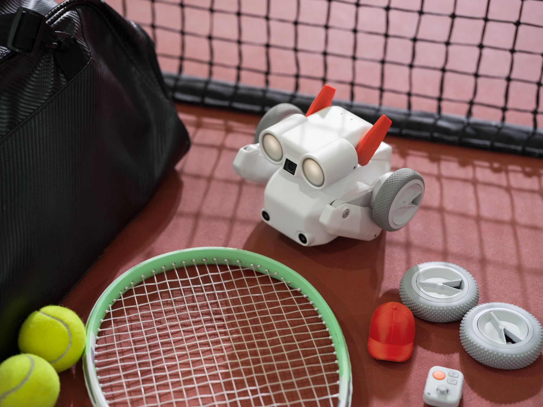 Beni camera robot beside tennis gear with indoor wheels and controller